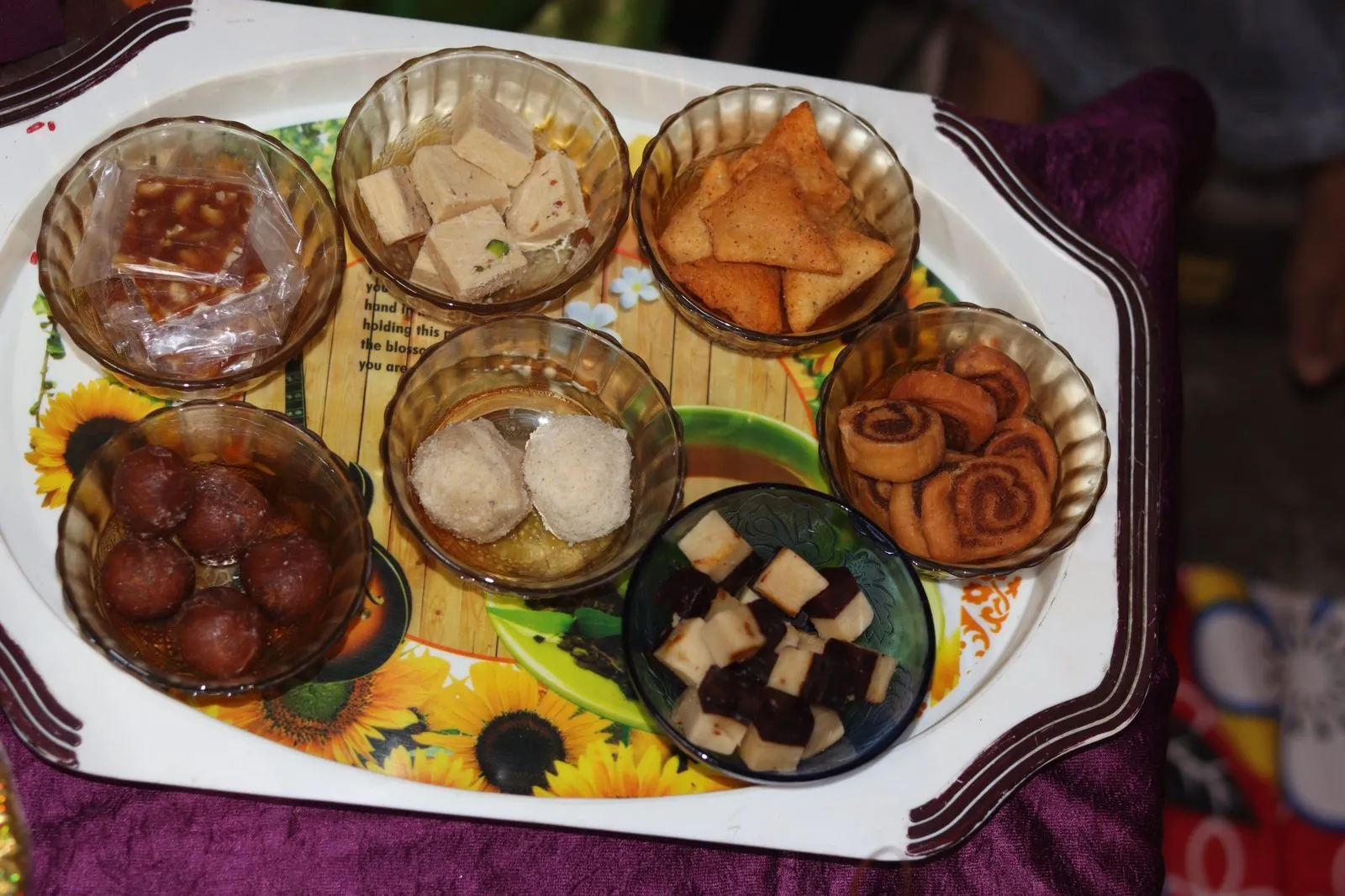 A tray of Indian sweets and snacks laid out for visiting family