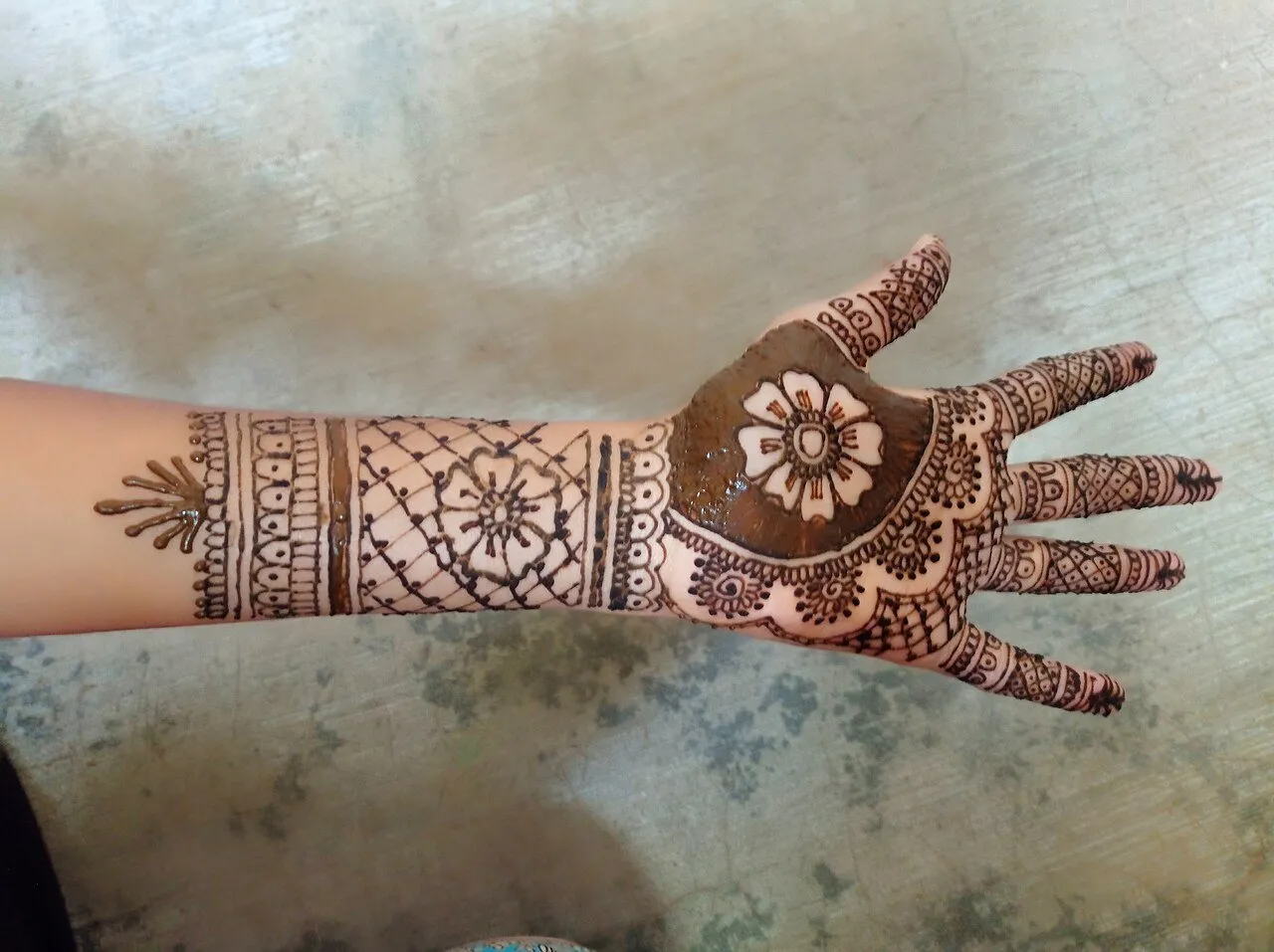 A hand decorated with fresh mehndi